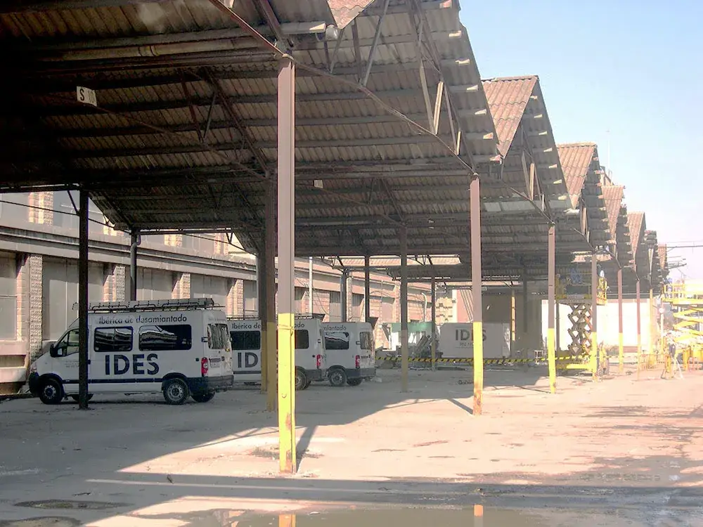 Furgonetas de Ibérica de Desamiantados (IDES) en una nave industrial.